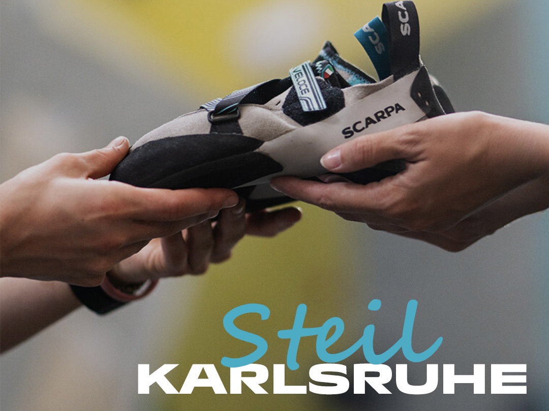 Hände geben Kletterschuhe weiter in Hände einer anderen Person. Diese Schuhe sind Teil der Scarpa Demo Tour in der Boulderhalle Steil in Karlsruhe .